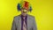 Clown businessman entrepreneur boss in wig adjusts his tie. Yellow background