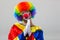 Clown praying over grey background