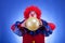 Clown in red costume with balloon in hands