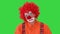 Clown with unhappy expression on his face walking in a funny way on a Green Screen, Chroma Key.