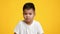 Clueless Korean Little Boy Shrugging Shoulders Posing Over Yellow Background
