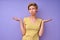 Clueless woman showing don't know gesture over isolated purple background.