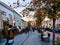 Cluj-Napoca, Romania - October 14, 2018: People walk on the promenade in front of a street cafe and relax on benches in the