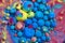 Cluster of blue and rainbow spheres on surface of colorful liquid