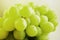 A cluster of green grapes on a white background