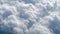 Cluster of large cumulus clouds, with tops pointing slightly to  right, aerial shot taken at altitude of ten thousand kilometers