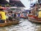 Cluster of long-tail boats with tourists and floating market vendors