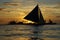 Cluster of sailboats silhouetted against a setting sun