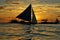 Cluster of sailboats silhouetted against a setting sun
