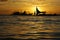 Cluster of sailboats silhouetted against a setting sun