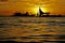 Cluster of sailboats silhouetted against a setting sun