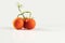 a cluster of tomatoes with drops on white background