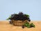 Clusters fruit black elderberry  Sambucus nigra  in basket on a wooden table on a blue background. Common names: black elder