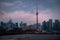 CN tower spire piercing menacing sky with dark clouds in dusk in Toronto ciy, Ontario, Canada