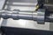 The CNC lathe machine cutting the aluminum rod