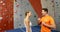 Coach assisting woman in bouldering 4k