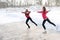 Coach of figure skating with apprentice practise at the frozen lake