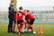 Coach Giving Young Soccer Team Instructions. Kids Sport Team Gathering. Children Play Sports