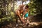 Coach helps a pregnant woman during exercises in the park