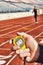 Coach holding Stopwatch Timing Runner