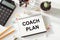 COACH PLAN written on nptepad. Training Planning Learning Coaching Business Guide