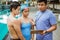 A coach shows a clipboard and a stopwatch to two teenage athletes