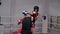 Coach training boxer man in helmet, gloves and groin protection on combat ring. Two boxer fighting on box training. Male