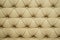 Coach-type leatherette screed tightened with buttons. Natural chesterfield style quilted upholstery backdrop. background texture