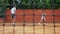 Coacher teaching young girl to playing tennis.