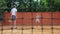 Coacher teaching young girl to playing tennis.