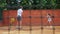 Coacher teaching young girl to playing tennis.