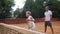 Coacher teaching young girl to playing tennis.