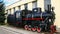 Coal-fired old black steam locomotive parked.