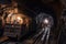 coal mine, with miners and equipment in motion, the sound of machinery echoing through the tunnel