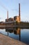 Coal power plant with reflection at dusk, industrial landscape.