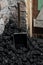 A coal shovel stuck in a pile of coalat the basement