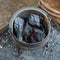 Coals burning in a bucket for kindling a fire top view