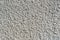 Coarse-grained textured gray background cement finish of the building facade with cement putty