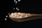 Coarse pink salt dropping on wooden spoon