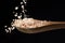 Coarse pink salt falling on wooden spoon