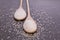 Coarse salt in wooden spoons on a black background