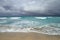 Coast of the Atlantic Ocean during a storm, waves on the sand, motor yacht on the horizon, low clouds, Varadero, Cuba