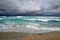 Coast of the Atlantic Ocean during a storm, waves on the sand, motor yacht on the horizon, low clouds, Varadero, Cuba