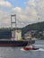 A coast guard boat escorts a large cargo ship sailing through the Bosphorus