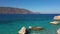 Coast landscape with mountains on background. Crystal blue sea.