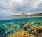 Coast with a lighthouse and fish with algae underwater