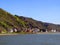Coast of the Rhine, Germany, wide fast river, many beautiful houses, mountain slopes, blue sky, spring greenery