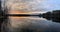 The coast at sunset, the picturesque sunset, quiet water, Mirror in water, clouds are illuminated by the sunset sun