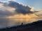 The coast at sunset, the picturesque sunset, quiet water, a sandy beach, clouds are illuminated by the sunset sun