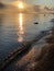 The coast at sunset, the picturesque sunset, quiet water, a sandy beach, clouds are illuminated by the sunset sun